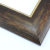 This bold, 2.5 " frame features a reverse profile design; it slopes from thickest at the inner edge to thin at the outer.  Overlapping brown, gold and deep red layers result in a faux wood-grain, rustic effect.  The cracked gold foil inner edge slants in toward the artwork. 

Best suited to large artwork; the perfect border to a rural or autumnal reproduction.